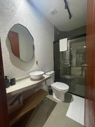 a bathroom with a toilet and a sink and a mirror at Villa Maui - Milagres in Passo de Camarajibe