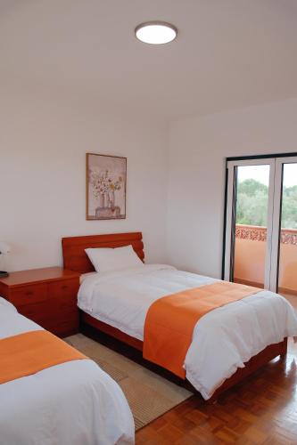 a bedroom with two beds and a window at Quinta da Shambhala in Soriço