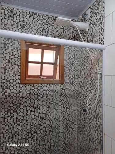 a bathroom with a shower with a window in it at Chalés confortáveis in Rio Grande