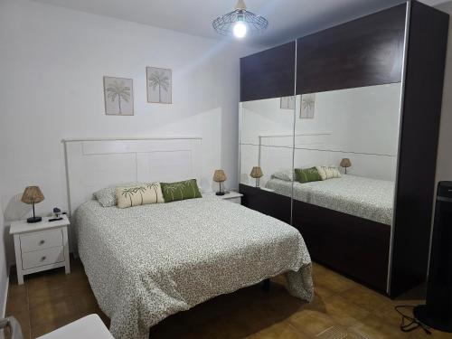 a bedroom with two beds and a mirror at Casa Memela 6 in Tías