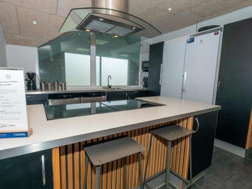a kitchen with a sink and two stools at Luxury Retreat in Vorupor in Snedsted