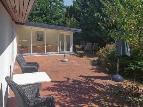a patio with two chairs and a table and a couch at 4 star holiday home in Hundested in Hundested