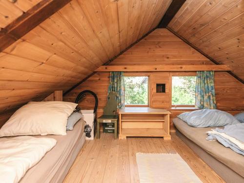 a bedroom with two beds and a desk in a cabin at 8 person holiday home in Hovborg-By Traum in Hovborg