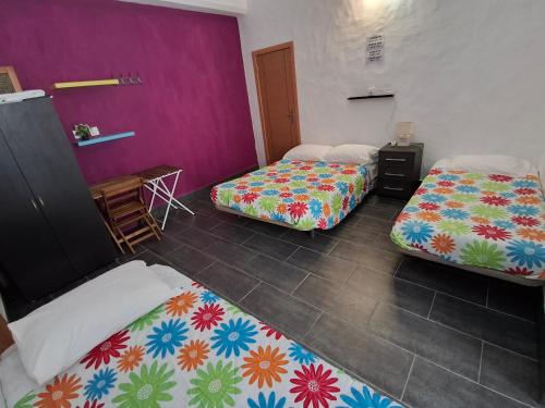 two beds in a room with purple and colorful walls at vila gira odeceixe in Odeceixe