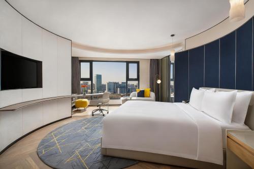 a hotel room with a large bed and a television at voco Xian ETDZ by IHG in Xi'an