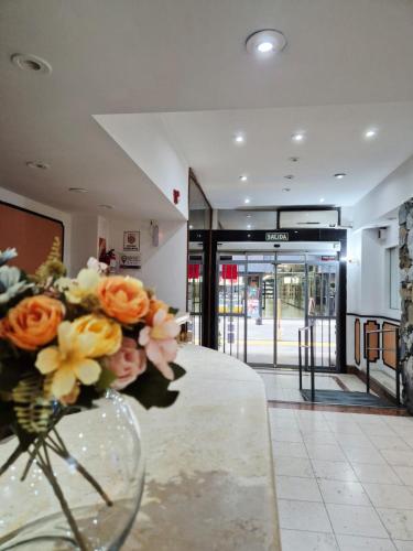a vase of flowers sitting on a table in a lobby at Village Garden Apart Hotel in Buenos Aires