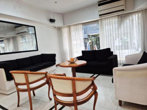 a living room with a couch and a table and chairs at Village Garden Apart Hotel in Buenos Aires