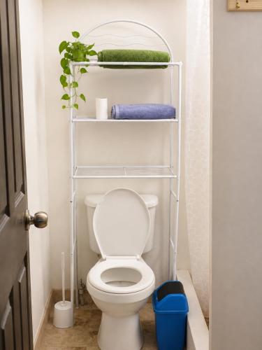 a bathroom with a white toilet and towels at The Frontside Surf House in Tamarindo