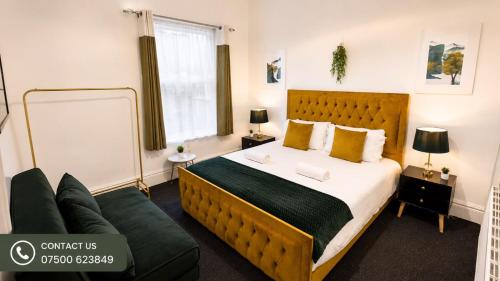 a bedroom with a large bed and a couch at Spacious Large Group House Near NEC and Airport in Birmingham