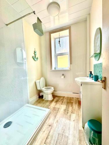 a bathroom with a shower and a toilet and a sink at The Hurstmere in Blackpool