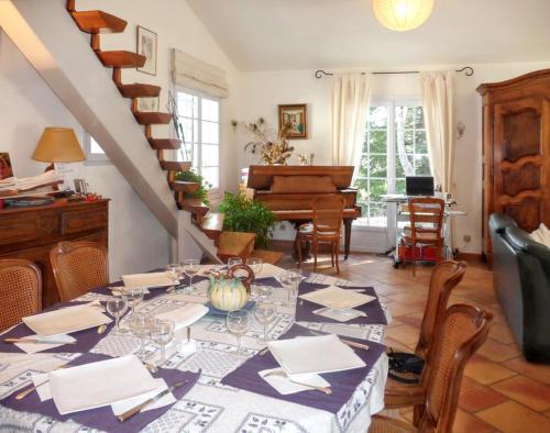 a dining room with a table and a piano at Villa élégante à Céreste avec piscine privée et jacuzzi in Céreste