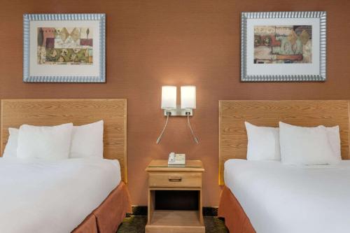 two beds in a hotel room with two lamps at Days Inn by Wyndham Columbus Fairgrounds in Columbus