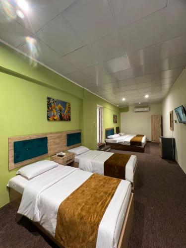 a hotel room with three beds in a room at Modern Palace Dawassah in Al Mawşil