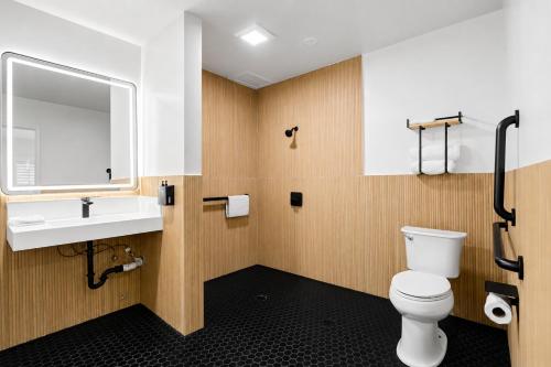 a bathroom with a toilet and a sink and a mirror at The Beverly House by AGA - Beverly Hills in Los Angeles