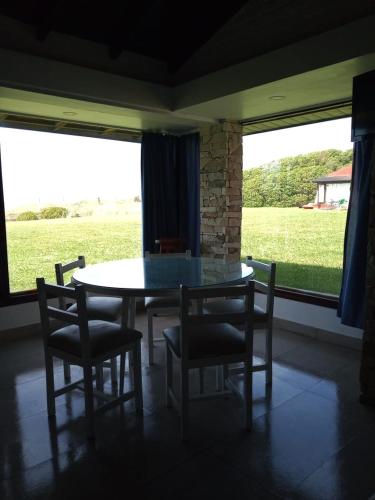a dining room with a table and chairs and a window at Complejo Casa Clara in Santa Clara del Mar