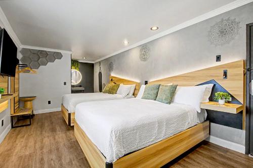 a large bedroom with two beds and a television at The Beverly House by AGA - Beverly Hills in Los Angeles
