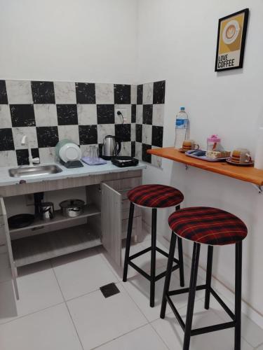 a kitchen with two bar stools in front of a counter at Alojamiento Ruta 51 in La Banda