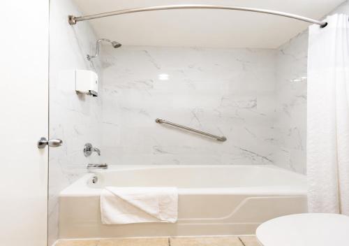 a white bathroom with a tub and a shower at King Frederik Inn in Solvang