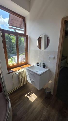 a bathroom with a white sink and a window at Penzion Adélka Janské Lázně in Janske Lazne
