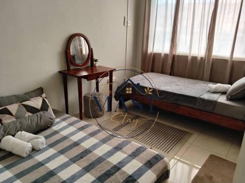 a bedroom with a bed and a mirror and a table at The MAST Stay "for islam people only" in Tampin