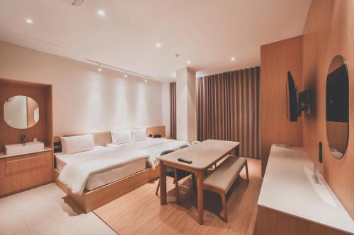 a bedroom with a bed and a table and a sink at 호텔 인썸니아 Hotel Insomnia 失眠酒店 in Daegu