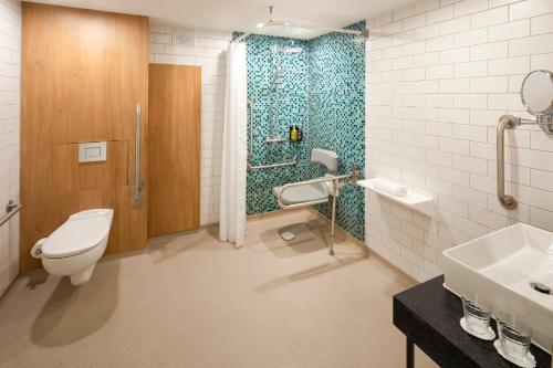 a bathroom with a toilet and a shower and a sink at Holiday Inn London-Bexley by IHG in Bexley