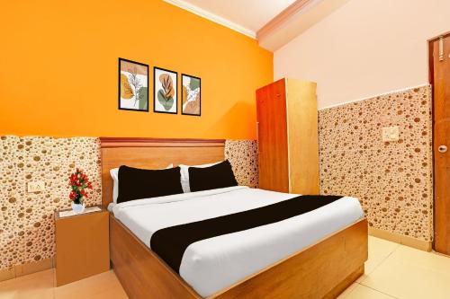 a bedroom with a bed in an orange room at Super Hotel O Kanode Gate Formerly Hotel Dhruv in Rewāri