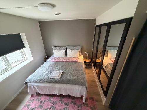 a small bedroom with a bed and a mirror at Trolladalen-Sogndal in Sogndal