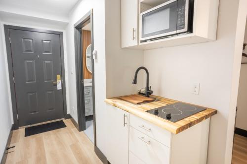 a small kitchen with a sink and a microwave at Sunshine Lodge Inn in Gibsons