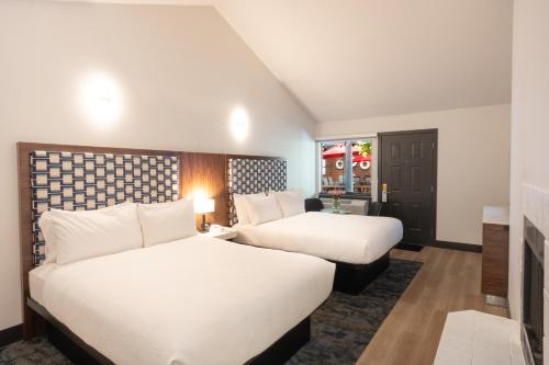 two beds in a hotel room with white sheets at Sunshine Lodge Inn in Gibsons