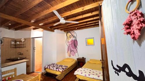 a room with two beds and a painting on the wall at Wanasa house in Dahab