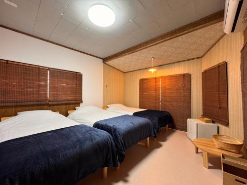 two beds in a room with two windows at Calmbase西伊豆いざよい in Numazu