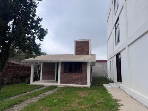 a brick house next to a white building at Hotel GUERRERO in Zacatlán