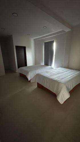 a large bed in a bedroom with a window at Hotel GUERRERO in Zacatlán