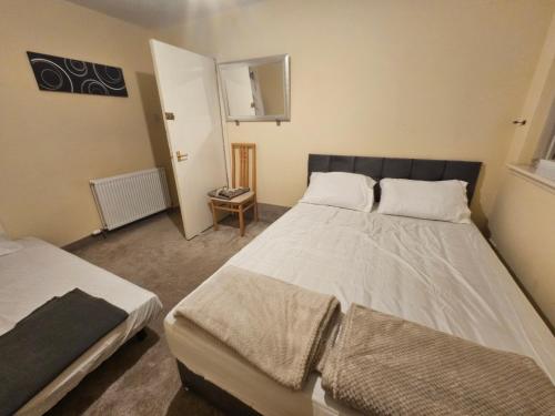 a bedroom with two beds in a room at Nad's Guest house in Motherwell