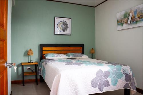 a bedroom with a bed in a room with green walls at Mi Barrio in Cartago