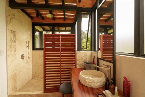 a bathroom with a large stone sink in a room at Origins Astral in Bagaces