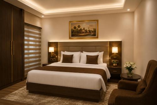 a bedroom with a large bed and a chair at Elite Gold Luxury Hotel in Abuja