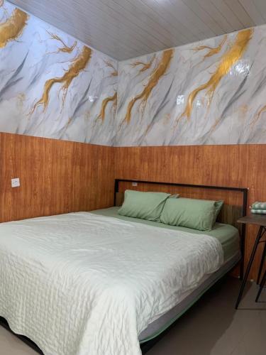 a bedroom with a bed with a painting on the wall at Sarasutha hotel and pool in Lembuak
