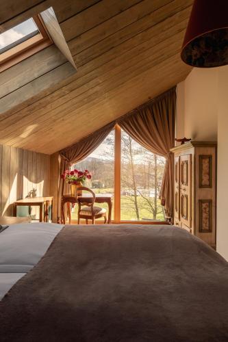a bedroom with a bed and a large window at CHATY U HARREGO NAD STAWEM SPA sauna, balia, rowery, klimatyzacja, in Kudowa-Zdrój