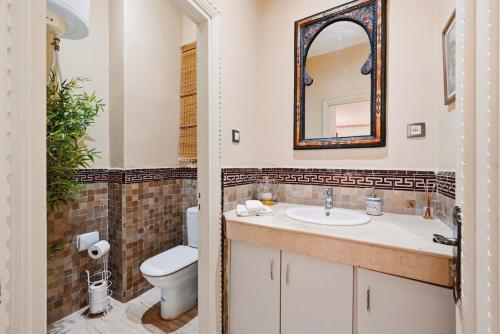 a bathroom with a sink and a toilet and a mirror at Villa des Roses in Marrakesh