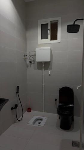 a white bathroom with a toilet and a window at شقة واسعة وانيقة in Hail