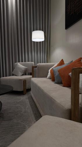 a living room with two couches and a lamp at شقة واسعة وانيقة in Hail