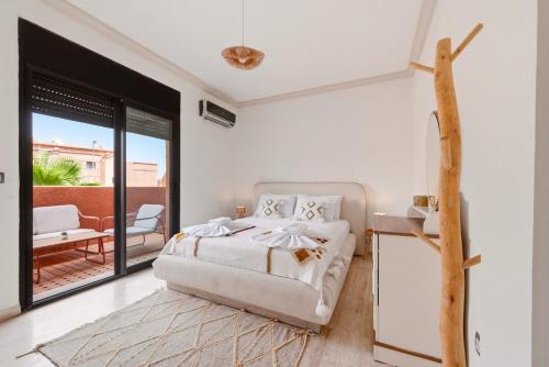 a white bedroom with a bed and a balcony at Villa des Roses in Marrakesh
