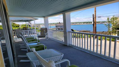 a porch with chairs and a view of the water at Oceanfront Classic Maine Cottage In Close Walking Distance To Beaches! in York