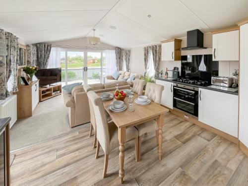 a kitchen and living room with a wooden table in a room at Sandy Shore - Uk37724 in Ingoldmells