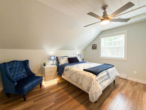 a bedroom with a bed and a ceiling fan and a chair at Riverside Retreat in Rexton
