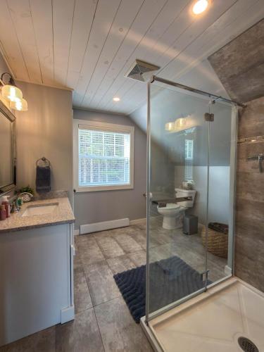 a bathroom with a shower and a sink and a toilet at Riverside Retreat in Rexton