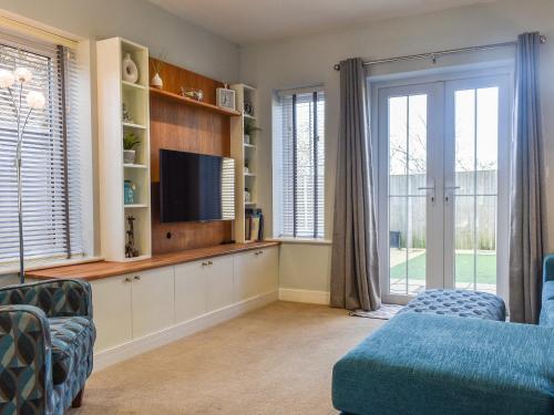 a living room with a tv and a couch at Coed Faen in Saint Helens