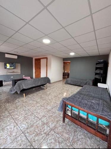 a large room with two beds and a tv at Aires de Mendoza in Maipú
